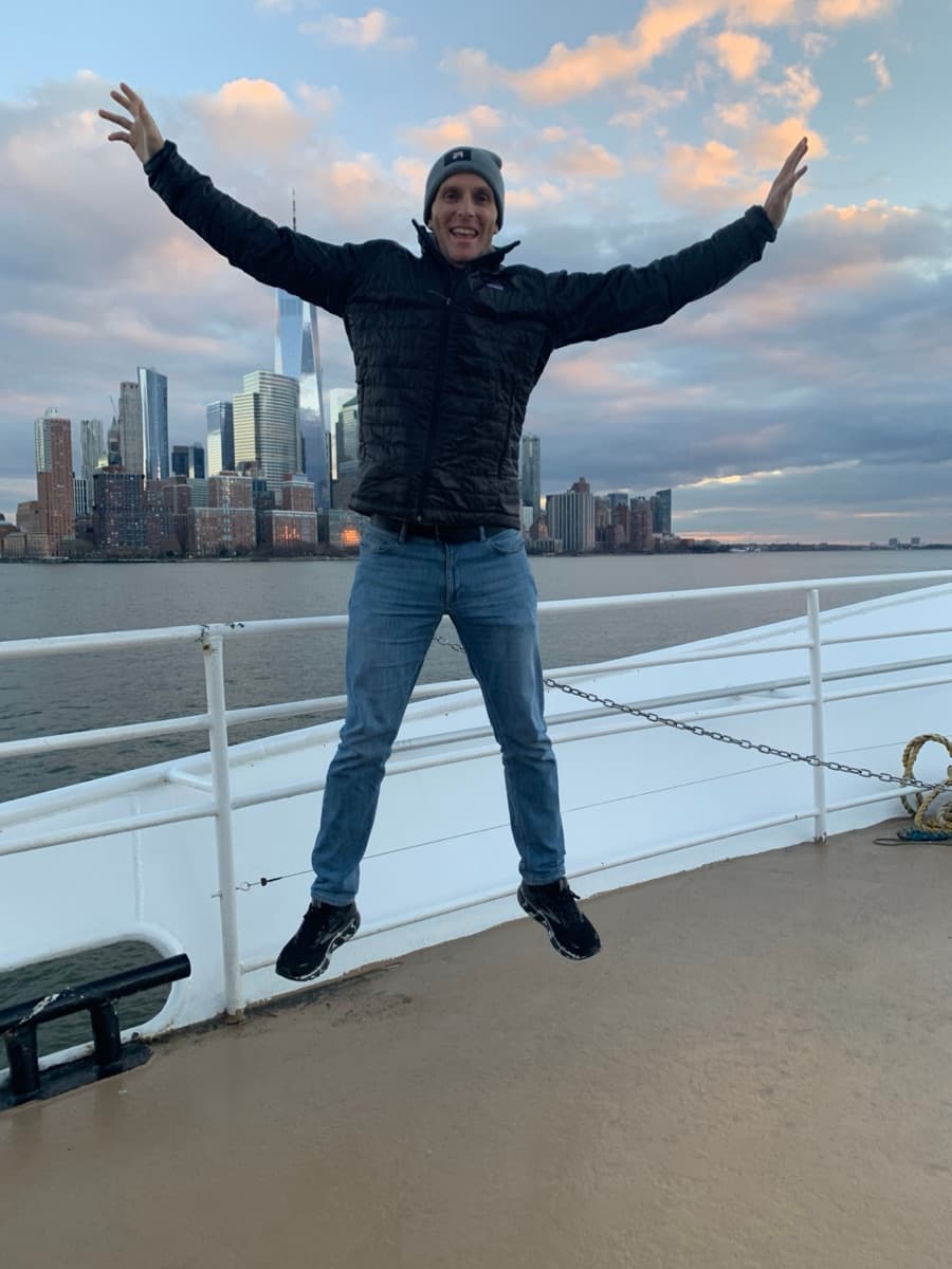 Jay with the New York City skyline behind him