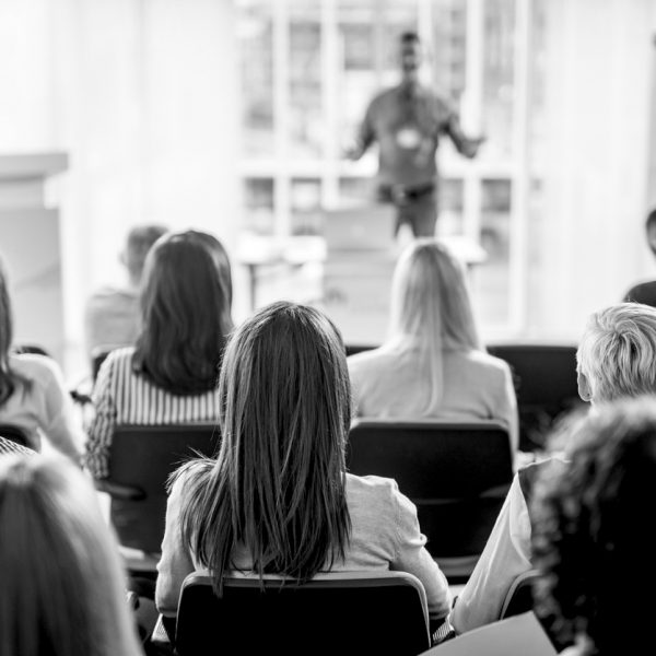 Back view of large group of business people having a training class in a board room.